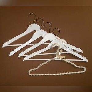Set of four white wooden hangers with single beaded hanger for the bridal party